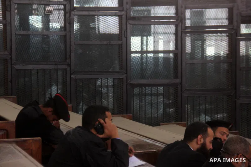 Suspects in the 'Ansar al-Sharia' case, stand in a courtroom cage during their trial in Cairo on March 14, 2015. Photo by Amr Sayed