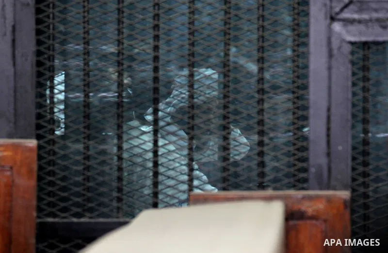 Suspects in the 'Ansar al-Sharia' case, stand in a courtroom cage during their trial in Cairo on March 14, 2015. Photo by Amr Sayed