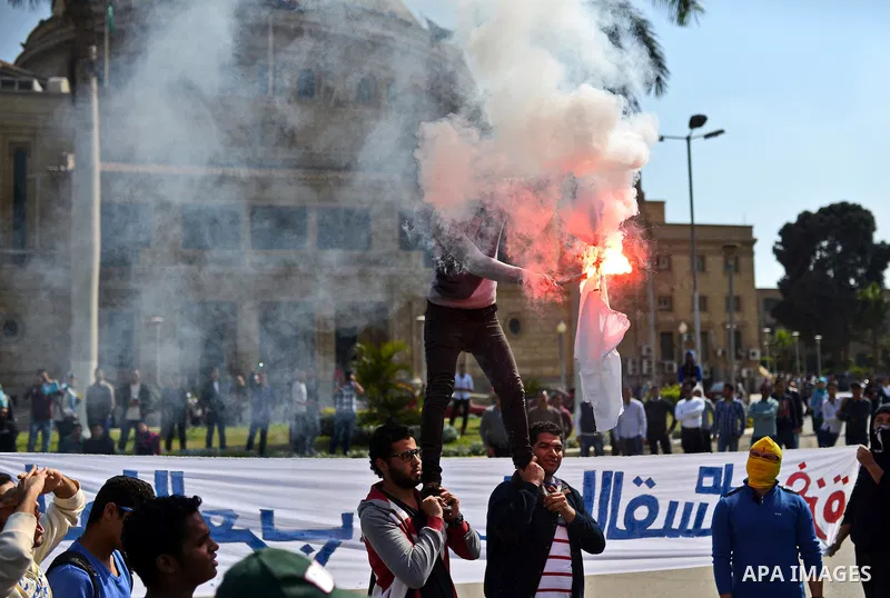 Egyptian students who support Muslim Brotherhood and ousted president Mohammed Morsi burn the Israeli flag during a demonstration in solidarity with the Islamic Palestinian movement of Hamas, at Cairo University on March...