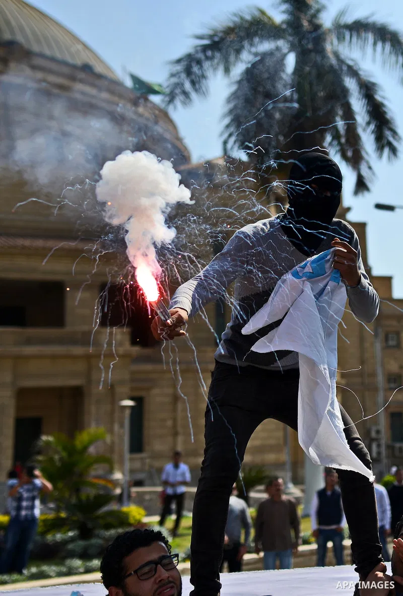 Egyptian students who support Muslim Brotherhood and ousted president Mohammed Morsi light flares during a demonstration in solidarity with the Islamic Palestinian movement of Hamas, at Cairo University on March 15, 2015...