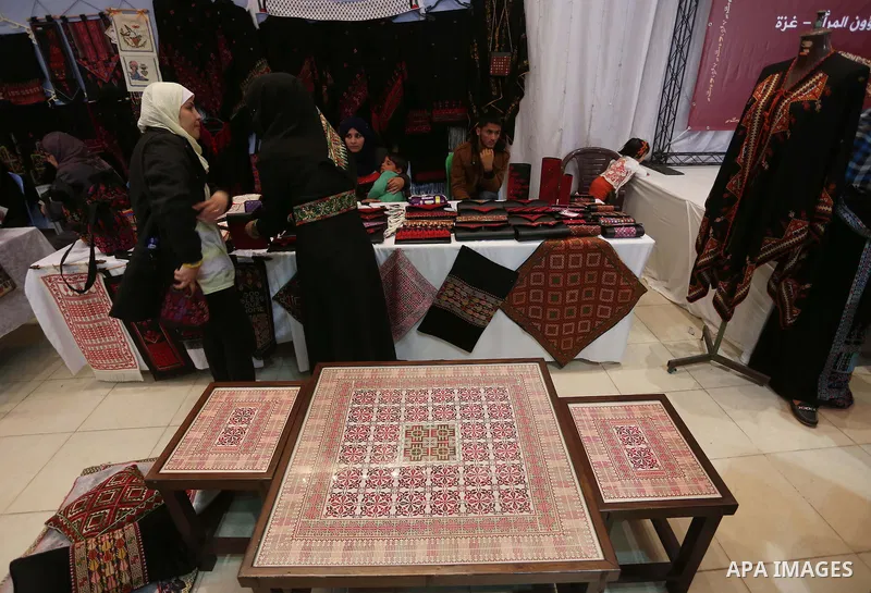 Palestinians participate in the opening of an exhibition of Palestinian heritage entitled "products of our women", in Gaza City, on March 16, 2015. Photo by Mohammed Asad