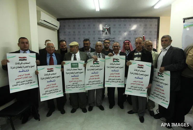 Palestinian Owners the association pilgrimage agencies and travel companies hold banners during a press conference, in Gaza city on March 18, 2015. Some 50,000 Gazans typically travel for the umrah each year, and travele...