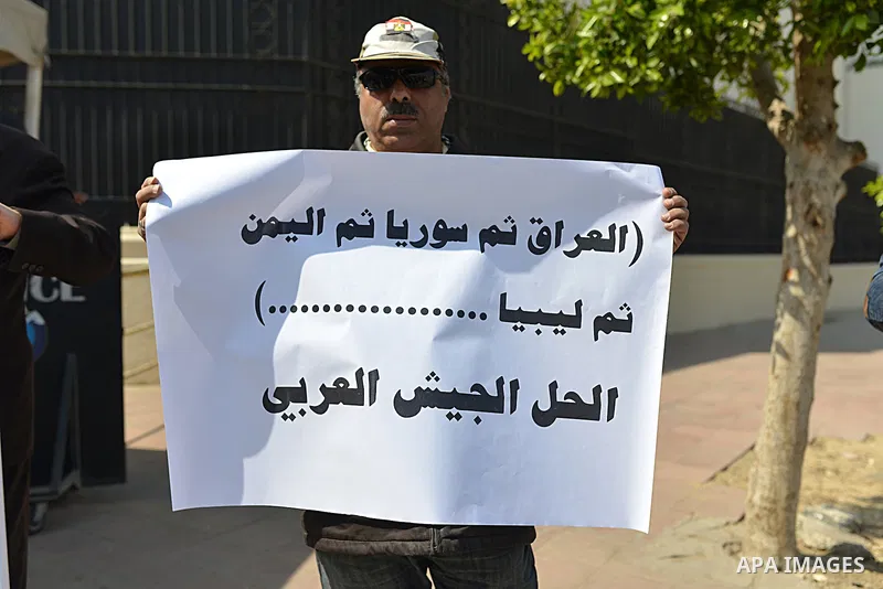 An Egyptian woman holds banners during a rally to support the Egyptian army and President Abdel Fattah al-Sisi, outside the Arab League headquarters, in Cairo on March 18, 2015. Photo by Amr Sayed