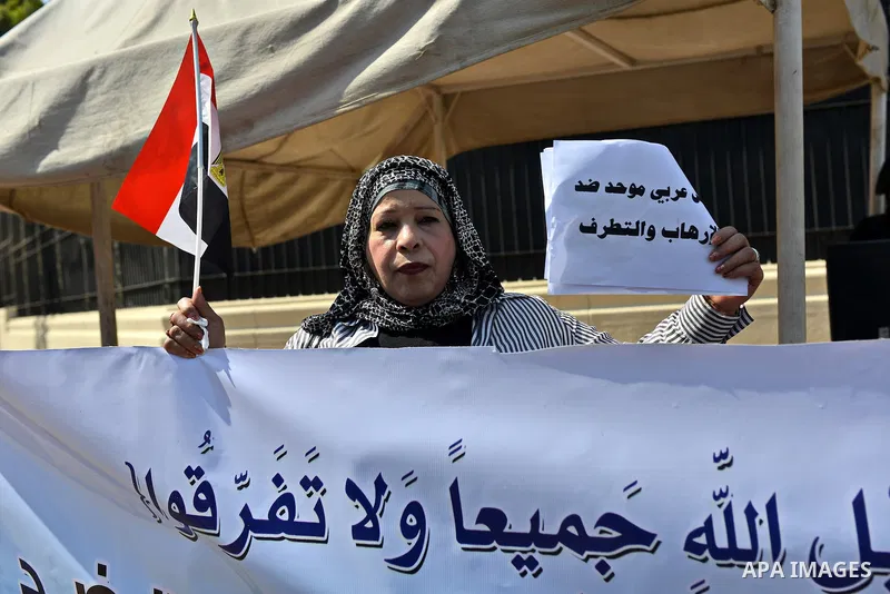 An Egyptian woman holds banners during a rally to support the Egyptian army and President Abdel Fattah al-Sisi, outside the Arab League headquarters, in Cairo on March 18, 2015. Photo by Amr Sayed