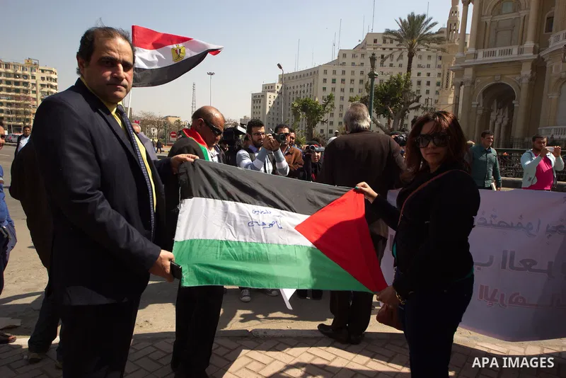 Egyptians hold a Palestinian flag during a rally to support the Egyptian army and President Abdel Fattah al-Sisi, outside the Arab League headquarters, in Cairo on March 18, 2015. Photo by Amr Sayed
