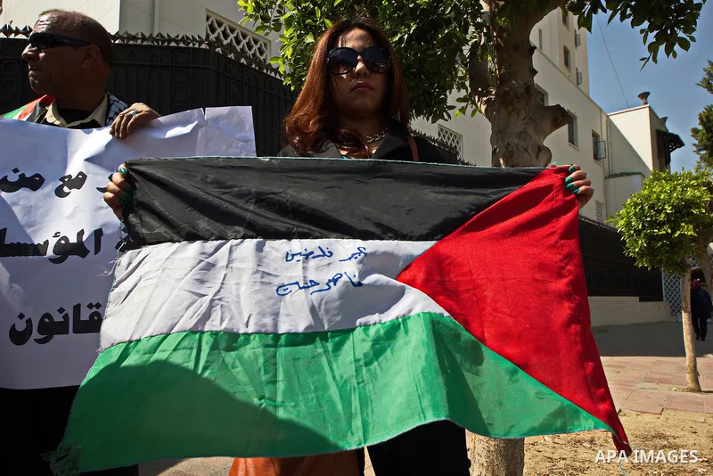 An Egyptian woman holds a Palestinian flag during a rally to support the Egyptian army and President Abdel Fattah al-Sisi, outside the Arab League headquarters, in Cairo on March 18, 2015. Photo by Amr Sayed