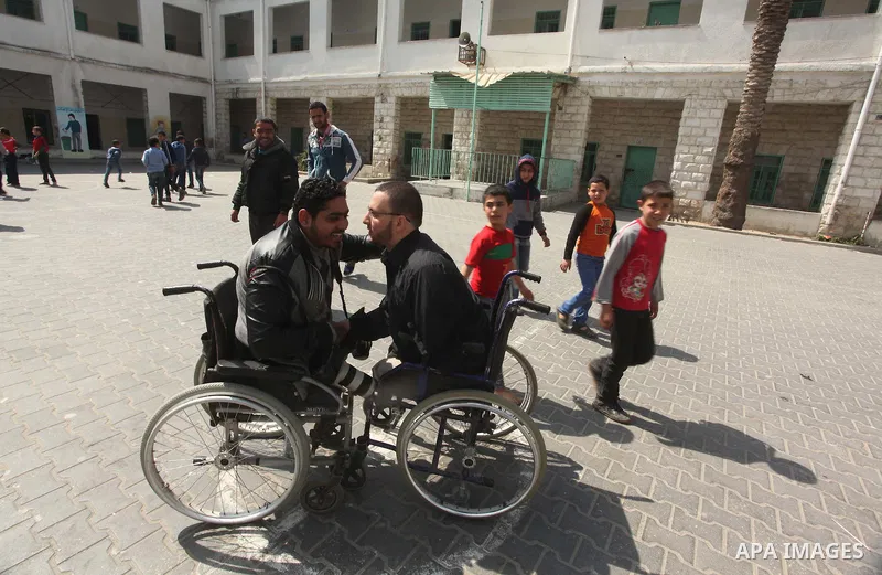 Wheelchair-bound Palestinian student teacher Ahmed al-Sawaferi, 25, who said that he lost his both legs and his left arm in an Israeli air strike in 2008, speaks with photographer at an elementary school in Gaza City Mar...