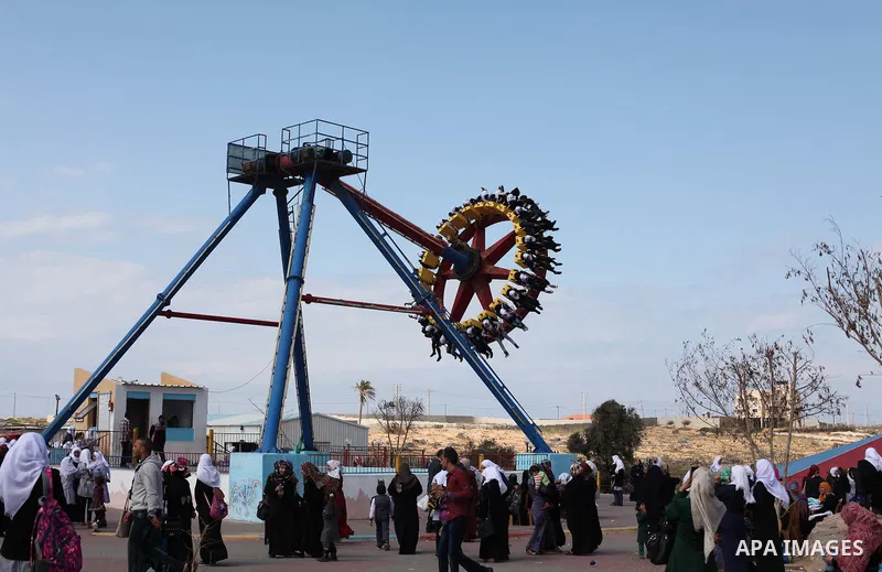 Palestinians enjoy playing games at an amusement park to mark the anniversary of Mother's Day, in Gaza City March 21, 2015. Photo by Ashraf Amra