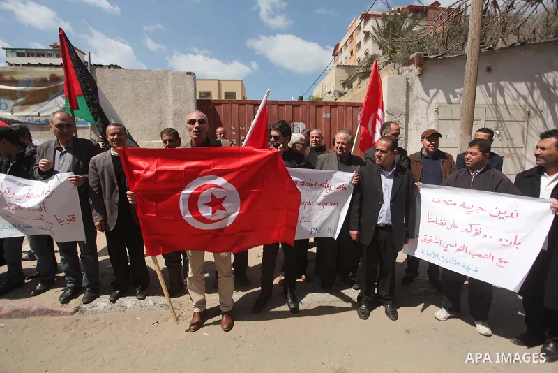 Palestinian take part in a protest to show solidarity with Tunisia after the terrorist attack at the Bardo Museum which caused 22 dead and 50 wounded among the tourists, in front of the Tunisian community, in Gaza city,...
