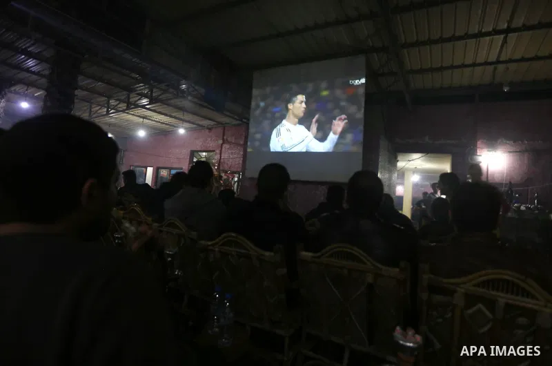 Palestinian youths watch a soccer match for Barcelona's team against Real Madrid team during the end of their Spanish first division "Clasico" soccer match at cafe, in Gaza city on March 22, 2015. FC Barcelona won 2-1 ag...