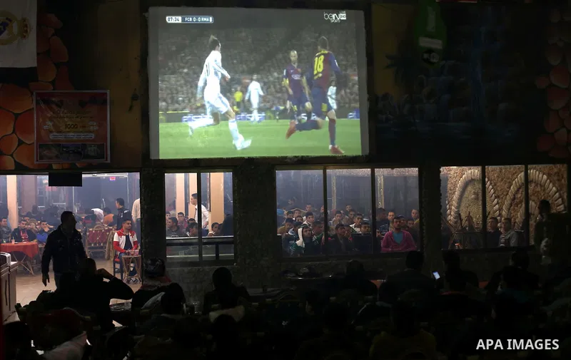 Palestinian youths watch a soccer match for Barcelona's team against Real Madrid team during the end of their Spanish first division "Clasico" soccer match at cafe, in Gaza city on March 22, 2015. FC Barcelona won 2-1 ag...