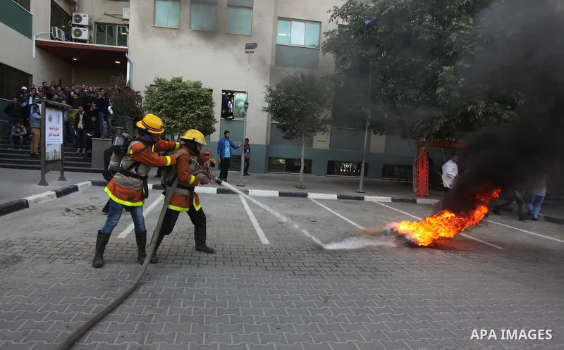 Palestinian Civil Defense members and students take part in a drill at a scene simulating a fire at University College of Applied Sciences by an Israeli air strike, in Gaza city March 24, 2015. Photo by Ashraf Amra