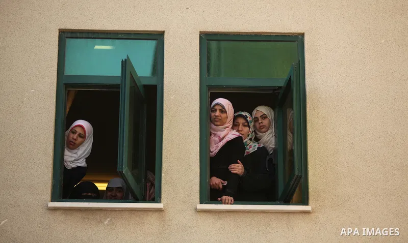 Palestinian students watch a drill at a scene simulating a fire at University College of Applied Sciences by an Israeli air strike, in Gaza city March 24, 2015. Photo by Ashraf Amra