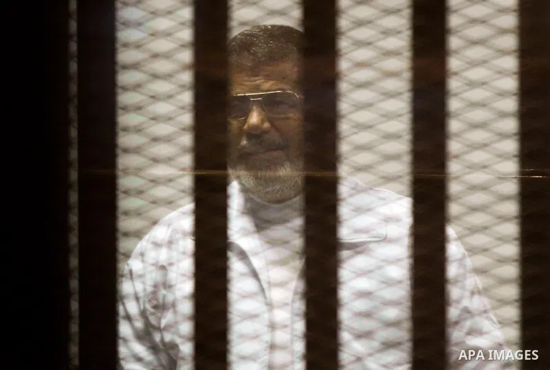 Egypt's deposed Islamist president Mohamed Morsi, is seen behind bars during his trial in a case of the "communicating with Qatar" at the court, in Cairo, on March 26, 2015. The session was held Wednesday to unseal the e...