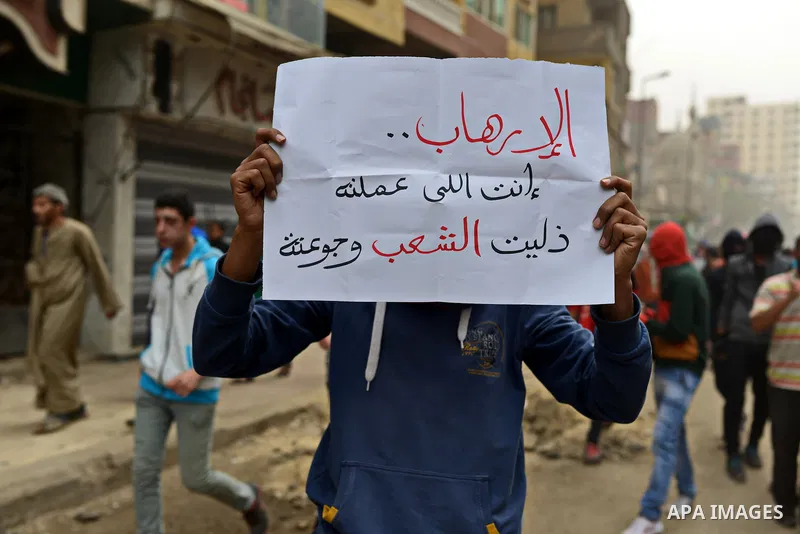 An Egyptian supporter of Muslim Brotherhood and ousted president Mohammed Morsi holds banner during a demonstration against military rule in al-Matariya district, in Cairo on March 27, 2015. Photo by Amr Sayed