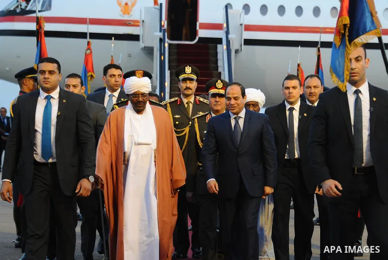 A handout picture made available by the Egyptian presidency shows Egyptian President Abdel Fattah al-Sisi (C-R) walking alongside Sudanese President Omar al-Bashir upon the latter's arrival in Red Sea resort of Sharm El-...