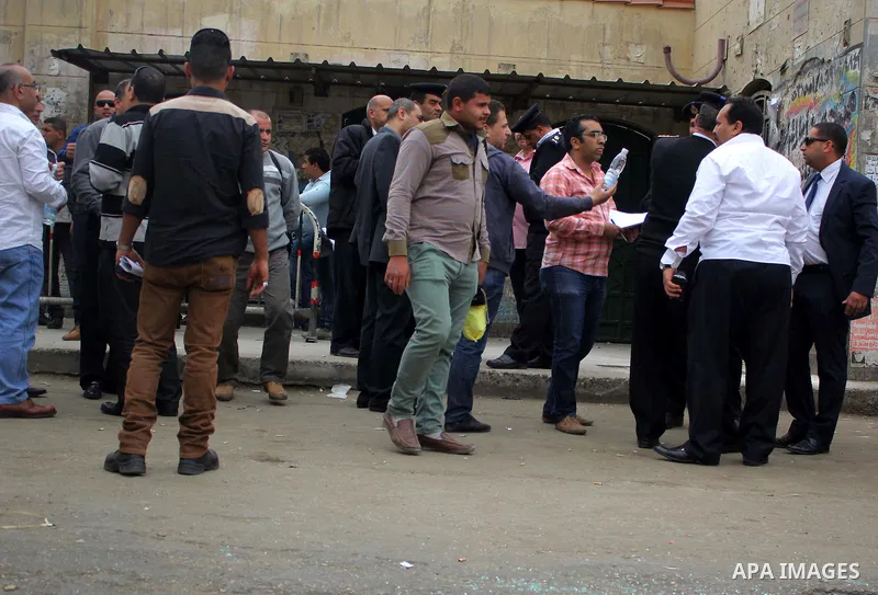 Egyptians gather at the scene of a bomb explosion outside the main gate of Cairo University, in Cairo, on march 28 , 2015. Eight people were injured during the explosion and sent to nearby hospitals, Health Ministry spok...