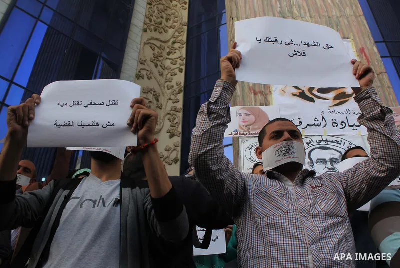 Egyptian Journalists, hold pictures of thier fellow Mayada Ashraf, during the first anniversary of her death by Egyptian police, in front of the Journalists Syndicate, in Cairo on March 30, 2015. Photo by Amr Sayed