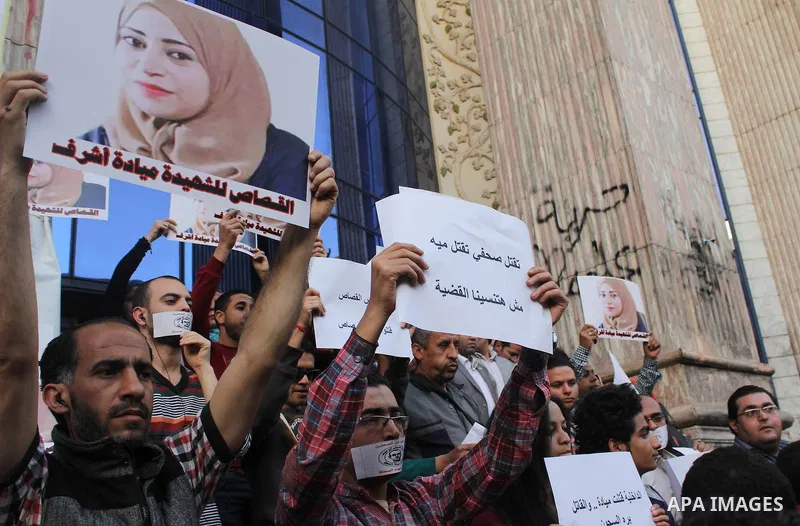 Egyptian Journalists, hold pictures of thier fellow Mayada Ashraf, during the first anniversary of her death by Egyptian police, in front of the Journalists Syndicate, in Cairo on March 30, 2015. Photo by Amr Sayed