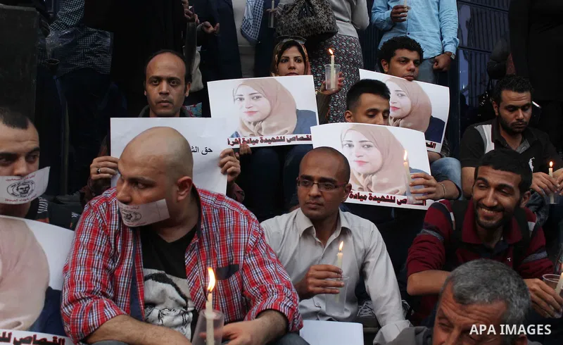Egyptian Journalists, hold pictures of thier fellow Mayada Ashraf, during the first anniversary of her death by Egyptian police, in front of the Journalists Syndicate, in Cairo on March 30, 2015. Photo by Amr Sayed