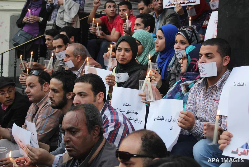 Egyptian Journalists, hold pictures of thier fellow Mayada Ashraf, during the first anniversary of her death by Egyptian police, in front of the Journalists Syndicate, in Cairo on March 30, 2015. Photo by Amr Sayed
