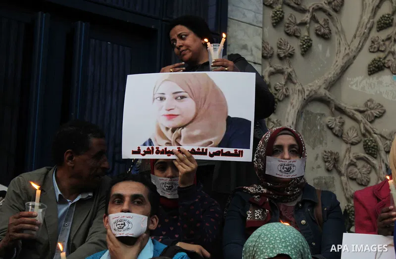 Egyptian Journalists, hold pictures of thier fellow Mayada Ashraf, during the first anniversary of her death by Egyptian police, in front of the Journalists Syndicate, in Cairo on March 30, 2015. Photo by Amr Sayed
