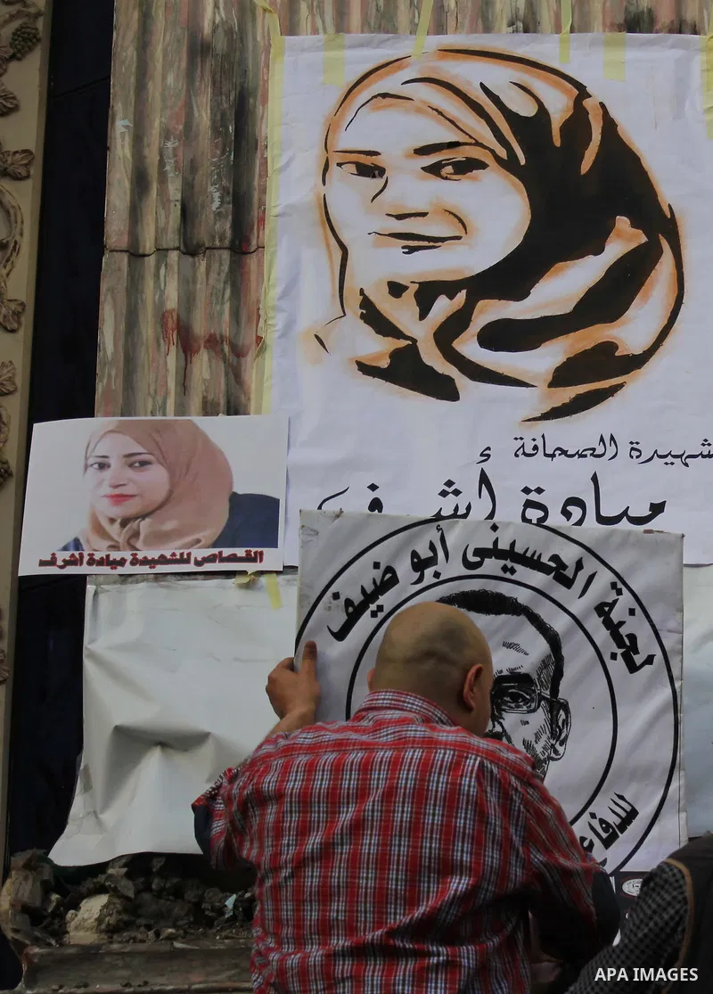 Egyptian Journalists, hold pictures of thier fellow Mayada Ashraf, during the first anniversary of her death by Egyptian police, in front of the Journalists Syndicate, in Cairo on March 30, 2015. Photo by Amr Sayed