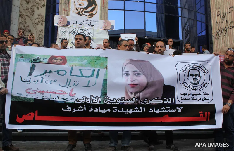Egyptian Journalists, hold pictures of thier fellow Mayada Ashraf, during the first anniversary of her death by Egyptian police, in front of the Journalists Syndicate, in Cairo on March 30, 2015. Photo by Amr Sayed
