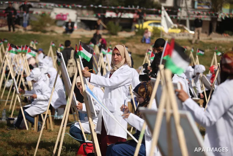 Palestinians artists paint artworks during an activity marking Land Day in Gaza City March 30, 2015. Palestinians mark Land Day on March 30, the annual commemoration of protests in 1976 against Israel's appropriation of...