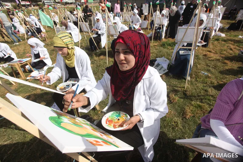 Palestinians artists paint artworks during an activity marking Land Day in Gaza City March 30, 2015. Palestinians mark Land Day on March 30, the annual commemoration of protests in 1976 against Israel's appropriation of...