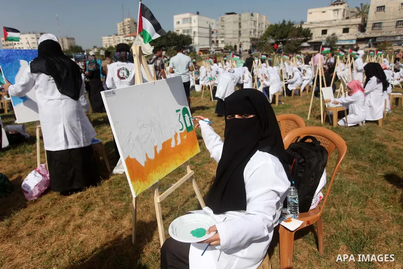 Palestinians artists paint artworks during an activity marking Land Day in Gaza City March 30, 2015. Palestinians mark Land Day on March 30, the annual commemoration of protests in 1976 against Israel's appropriation of...