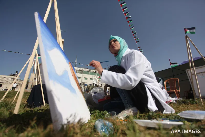 Palestinians artists paint artworks during an activity marking Land Day in Gaza City March 30, 2015. Palestinians mark Land Day on March 30, the annual commemoration of protests in 1976 against Israel's appropriation of...