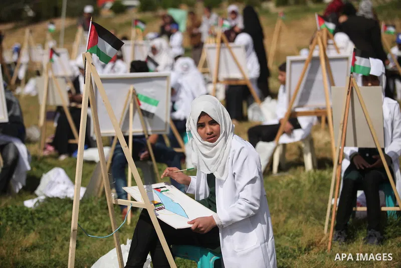 Palestinians artists paint artworks during an activity marking Land Day in Gaza City March 30, 2015. Palestinians mark Land Day on March 30, the annual commemoration of protests in 1976 against Israel's appropriation of...