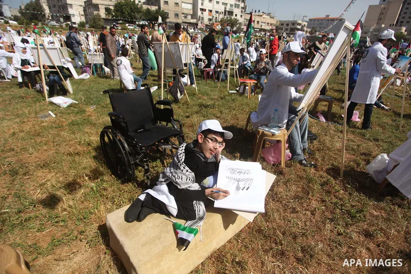 Palestinians artists paint artworks during an activity marking Land Day in Gaza City March 30, 2015. Palestinians mark Land Day on March 30, the annual commemoration of protests in 1976 against Israel's appropriation of...