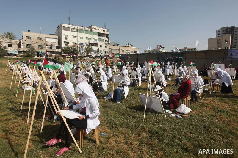 Palestinians artists paint artworks during an activity marking Land Day in Gaza City March 30, 2015. Palestinians mark Land Day on March 30, the annual commemoration of protests in 1976 against Israel's appropriation of...
