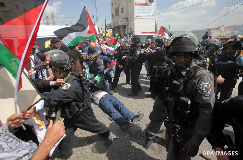 Palestinian protesters argue with an Israeli border policeman during clashes following a protest marking Land Day in the West Bank town of Hawara near Nablus March 30, 2015. Palestinians mark Land Day on March 30, the an...