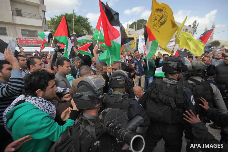 Palestinian protesters argue with an Israeli border policeman during clashes following a protest marking Land Day in the West Bank town of Hawara near Nablus March 30, 2015. Palestinians mark Land Day on March 30, the an...