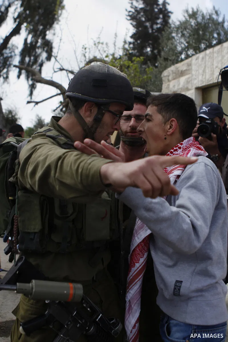 Palestinian protesters scuffle with an Israeli border policeman during a protest marking the Land Day in the West Bank village of Silwad near Ramallah March 30, 2015. Palestinians mark Land Day on March 30, the annual co...
