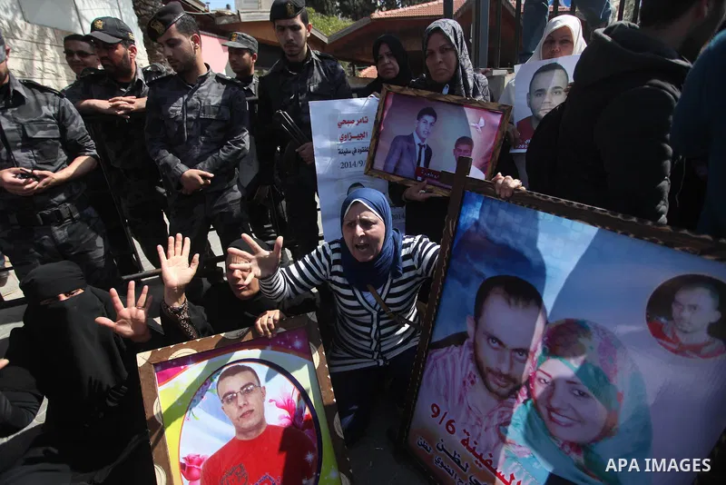 Palestinians hold pictures of their missing relatives during a protest, in front of the headquarters Council of Ministers in Gaza city on March 31, 2015. Gazans are missing after one of the deadliest migrant shipwrecks o...