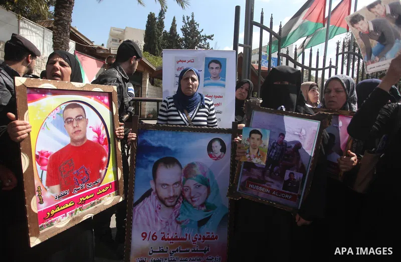 Palestinians hold pictures of their missing relatives during a protest, in front of the headquarters Council of Ministers in Gaza city on March 31, 2015. Gazans are missing after one of the deadliest migrant shipwrecks o...