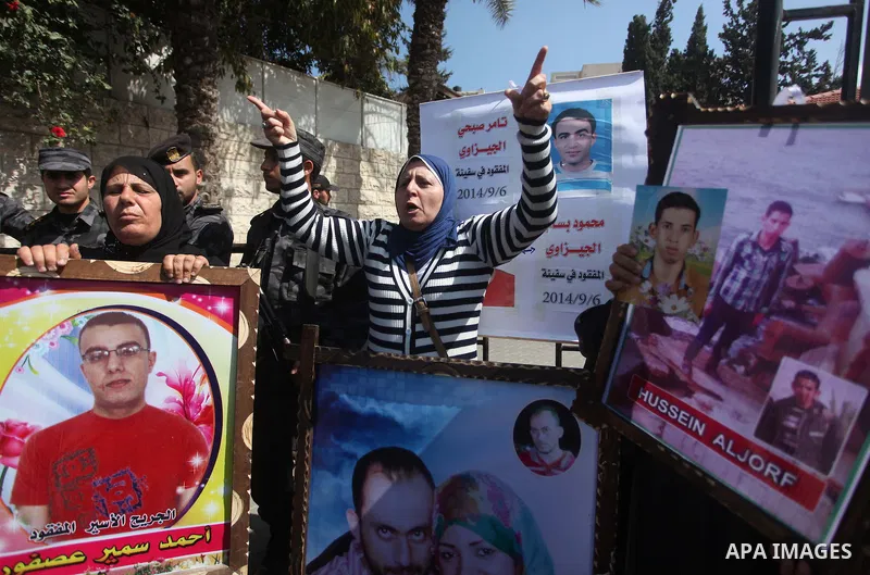 Palestinians hold pictures of their missing relatives during a protest, in front of the headquarters Council of Ministers in Gaza city on March 31, 2015. Gazans are missing after one of the deadliest migrant shipwrecks o...