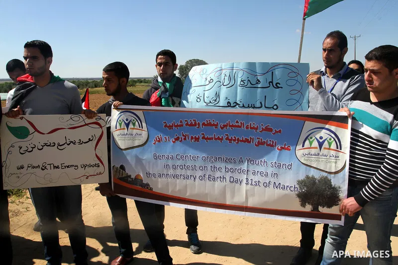Palestinians hold banners during a rally to mark Land Day held in the village of Abassan, east of Khan Yunis near the border fence between Israel and the southern Gaza Strip on March 31, 2015. On the annual Land Day, dem...
