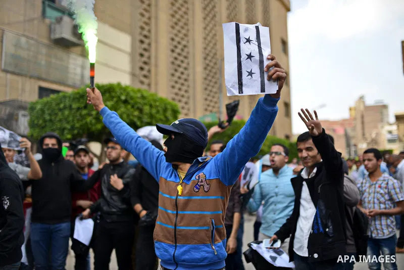 An Egyptian students who support Muslim Brotherhood and ousted president Mohammed morsi lights flares slogans during a protest in solidarity with Syrian people, at Cairo University on April 1, 2015. International donors...