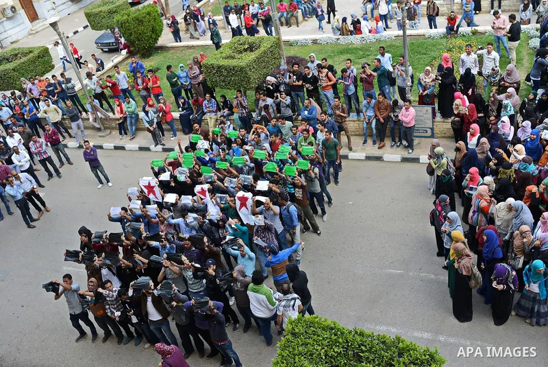Egyptian students who support Muslim Brotherhood and ousted president Mohammed morsi hold banners and shout slogans during a protest in solidarity with Syrian people, at Cairo University on April 1, 2015. International d...