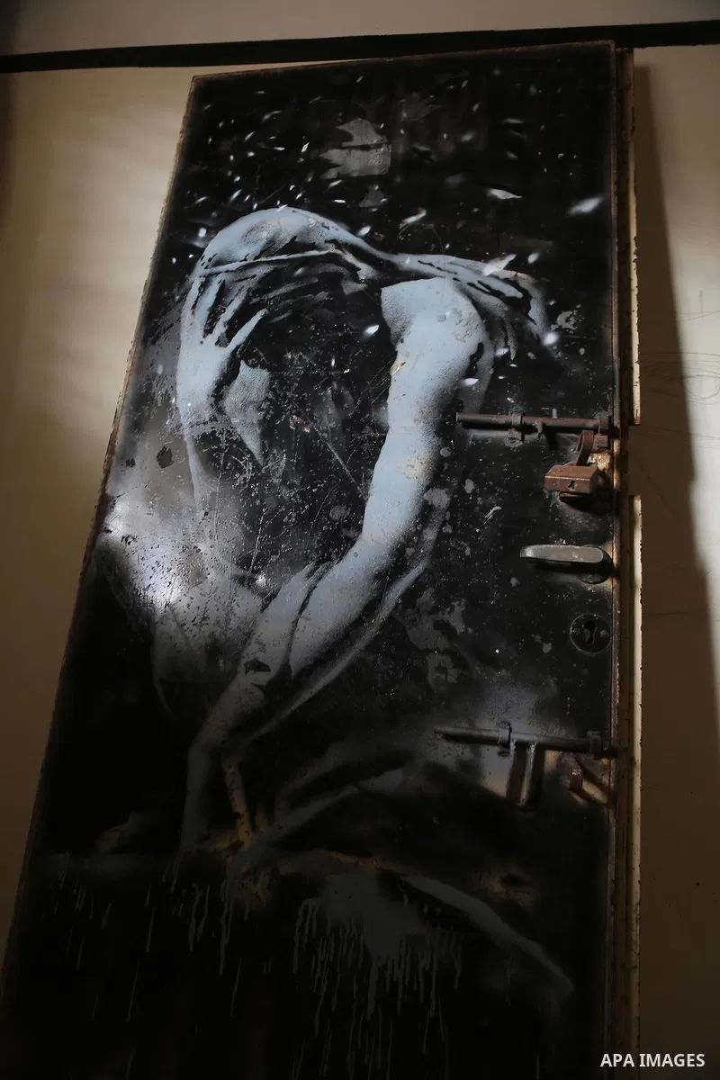 A picture taken in Khan Yunis, in the southern Gaza Strip on April 2, 2015, shows a mural of a weeping woman, said to have been painted by British street artist Banksy, on the door of a house that was destroyed during th...