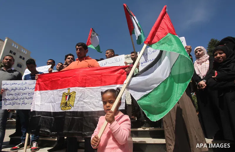 Palestinians hold banners during a protest demanding the Egyptian authorities for the opening of the Rafah crossing in Gaza city, on April 2, 2015. Photo by Ashraf Amra