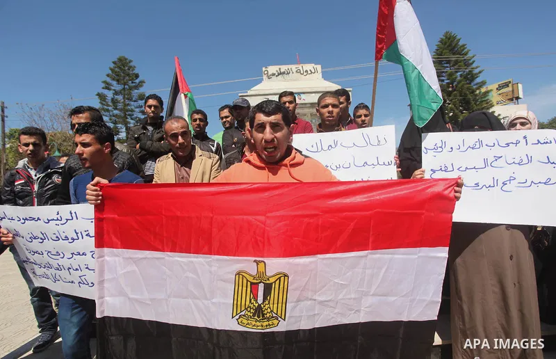 Palestinians hold banners during a protest demanding the Egyptian authorities for the opening of the Rafah crossing in Gaza city, on April 2, 2015. Photo by Ashraf Amra