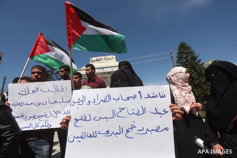 Palestinians hold banners during a protest demanding the Egyptian authorities for the opening of the Rafah crossing in Gaza city, on April 2, 2015. Photo by Ashraf Amra