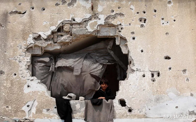 A Palestinian boy looks on from his family's house that was destroyed during the 50-day Israeli war on Gaza Strip in the summer of 2014, in Gaza City's al-Shejaiya neighbourhood, on April 2, 2015. The Palestinians formal...