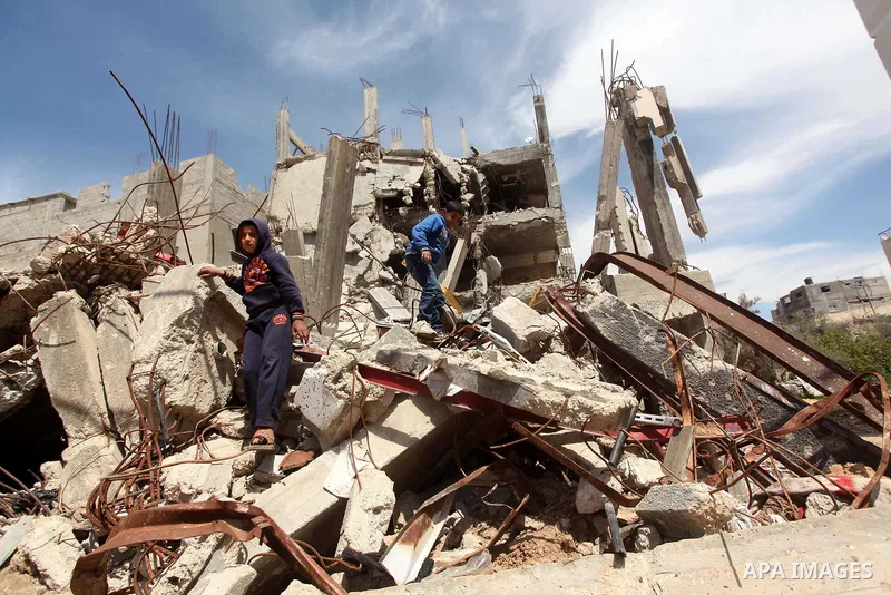 Palestinian children walk on the rubble of buildings that were destroyed during the 50-day Israeli war on Gaza Strip in the summer of 2014, in Gaza City's al-Shejaiya neighbourhood, on April 2, 2015. The Palestinians for...